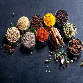 Various spices in a bowls on white background. Top view with copy space